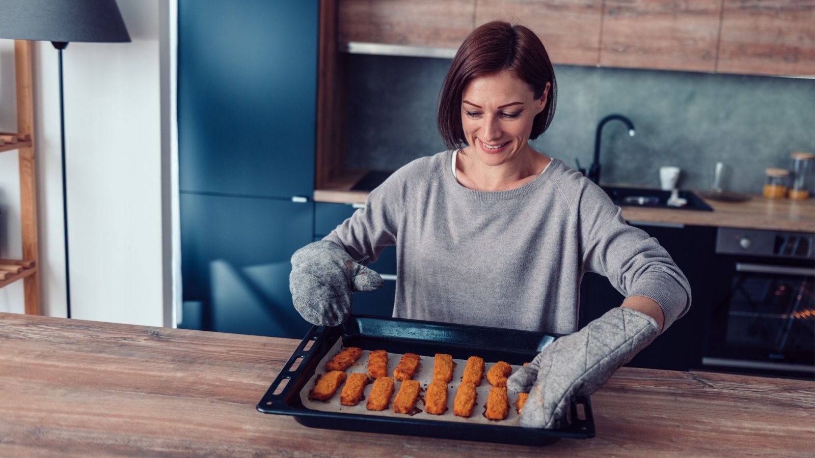 Woman Making Chicken Nuggets Fish Sticks Dinner Lunch Zivica Kerkez Shutterstock