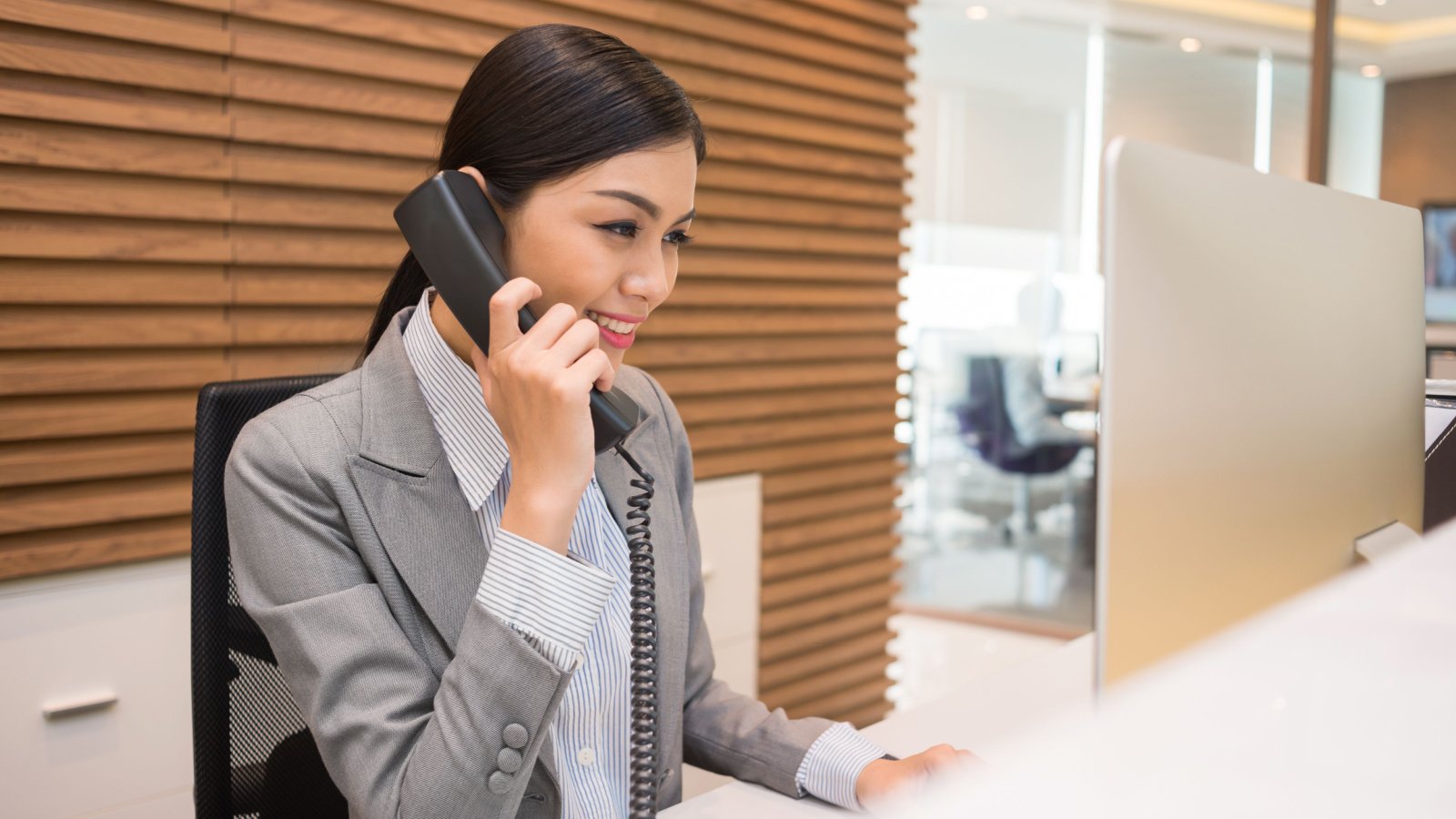 Woman POC phone assistant receptionist office Dragon Images Shutterstock