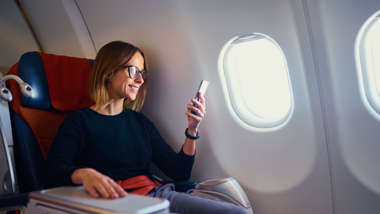 Woman airplane travel work phone kudla Shutterstock