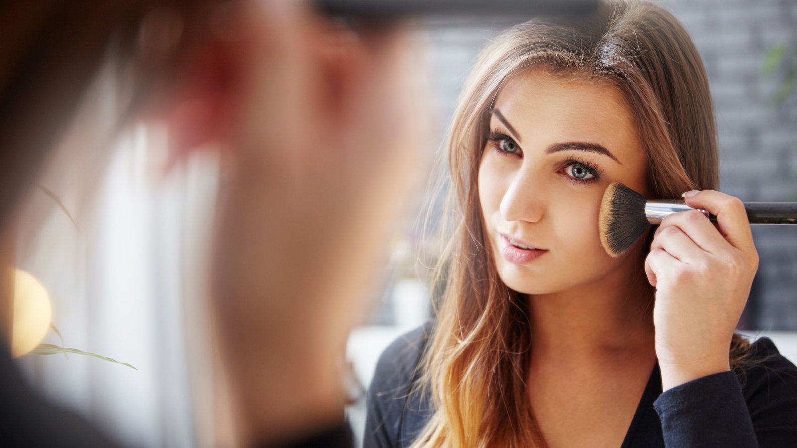 Woman applying makeup InnerVisionPRO Shutterstock