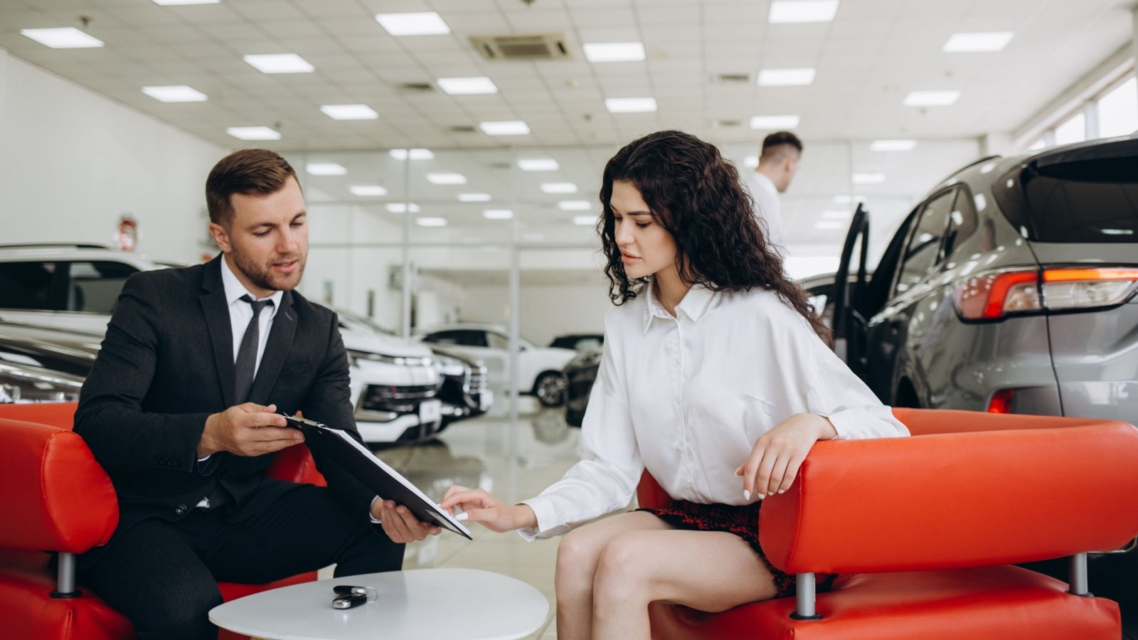 Woman buying a car at the dealership Roman Fenton Shutterstock