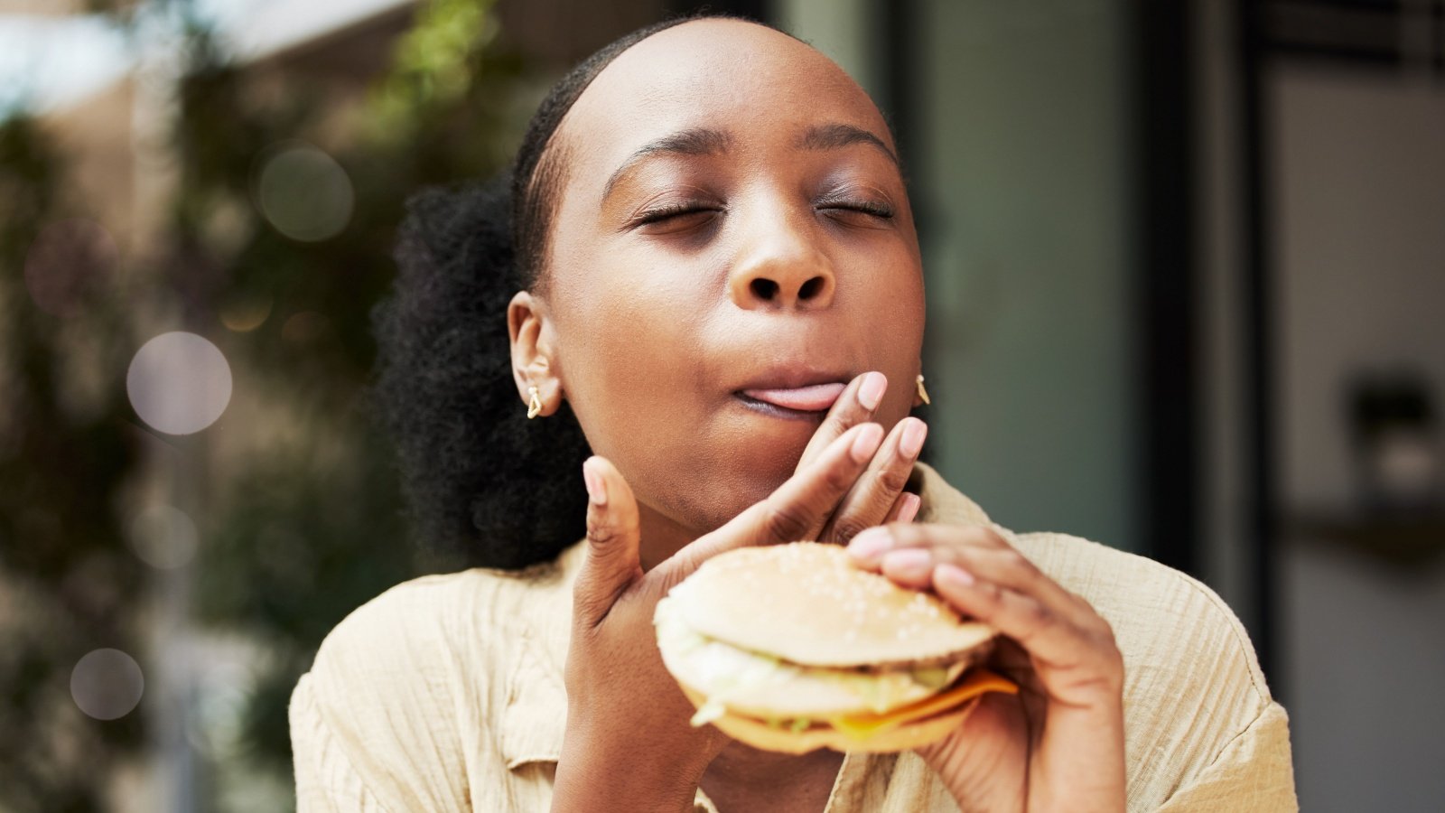 Woman eating sandwich burger breakfast food restaurant PeopleImagescom Yuri A Shutterstock