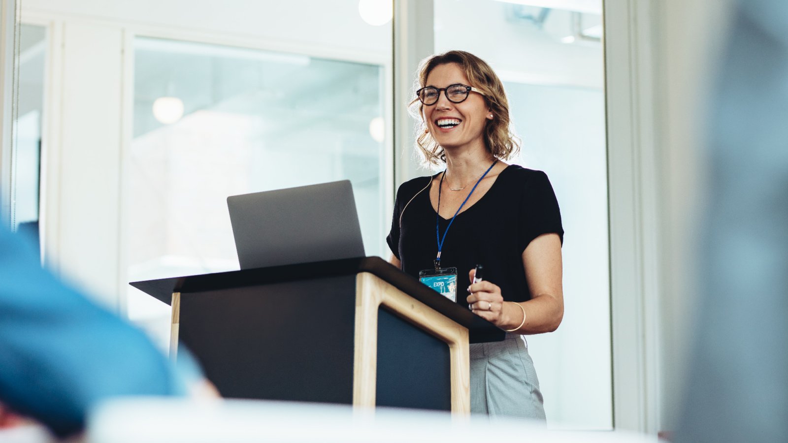 Woman public speaking smiling confident work Jacob Lund Shutterstock