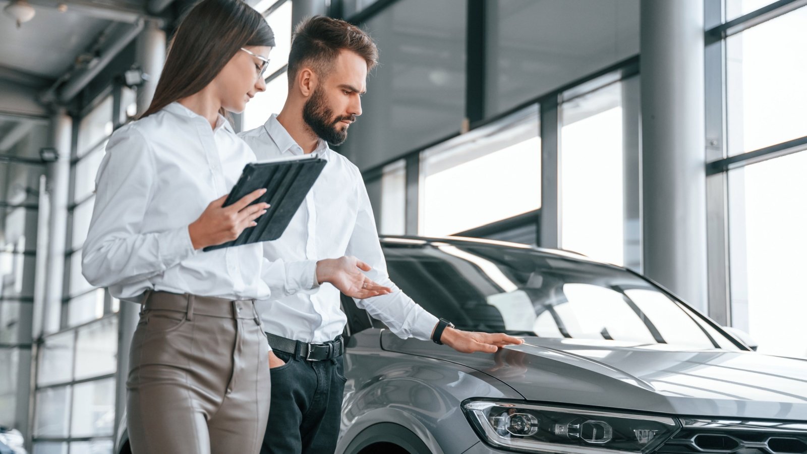 Young couple buying a car at a dealership Standret Shutterstock