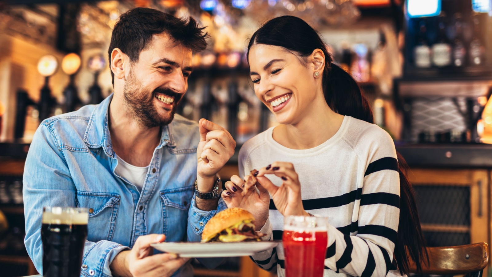 Young couple date with beer and burger at a restaurant adriaticfoto Shutterstock