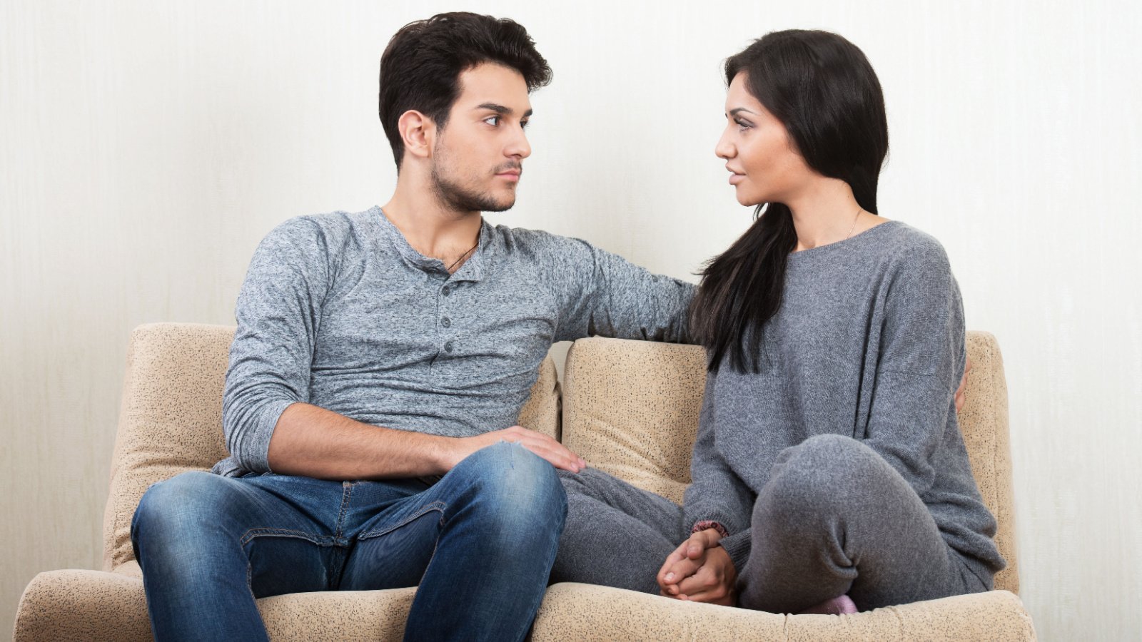 Young happy couple talking together sitting on a sofa valery sidelnykov shutterstock