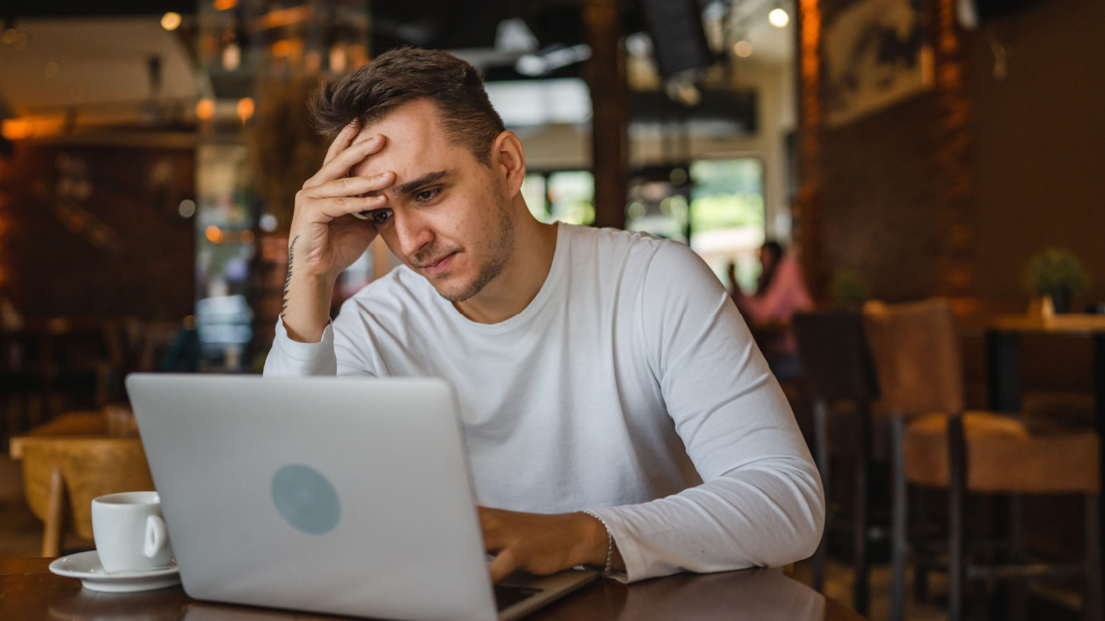 Young male worried concern laptop computer coffee Miljan Zivkovic Shutterstock