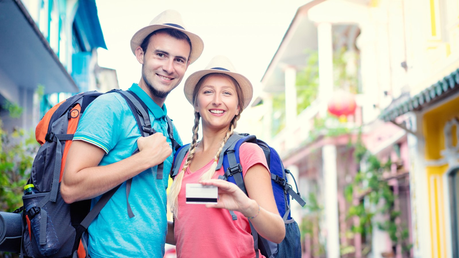 Young traveling couple holding credit card Kudla Shutterstock