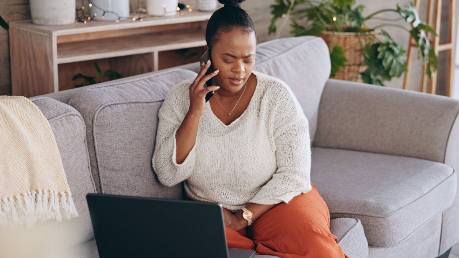 black african american woman on a sofa in the living room couch phone call stress concerned worry worried PeopleImagescom Yuri A Shutterstock