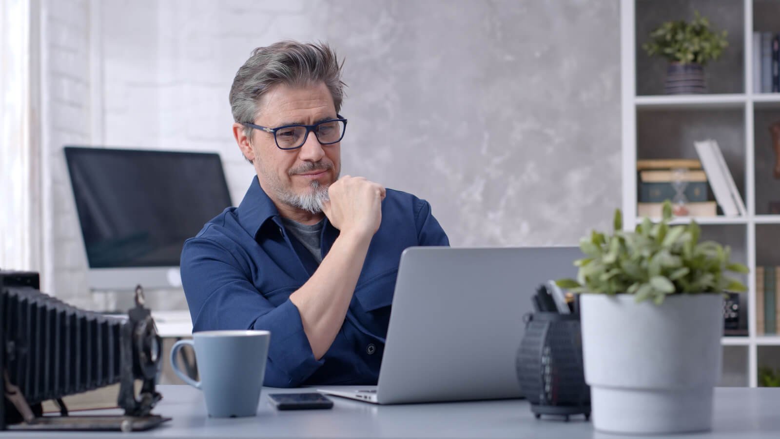 business father working online with laptop computer at home sitting at desk investor stocklite shutterstock