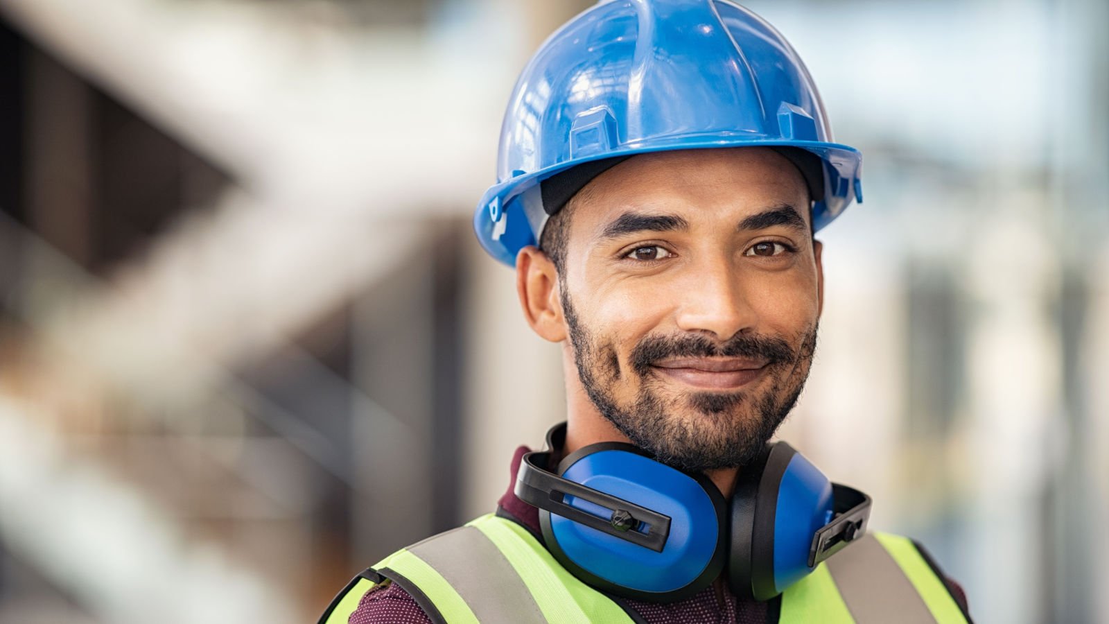 construction site manager wearing safety vest and blue helmet jobs ground picture:shutterstock