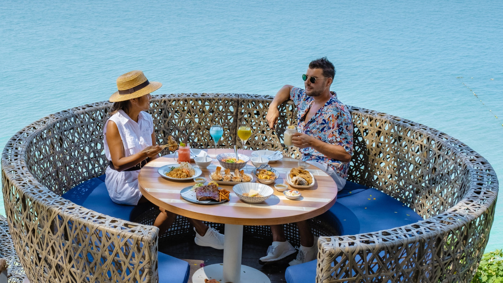 couple having meal at a restaurant looking out over the ocean