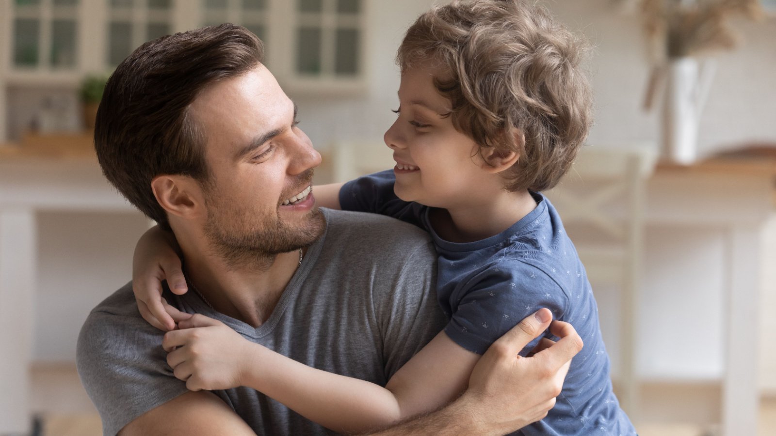 dad caressing touching son sitting on sofa at home father fizkes shutterstock