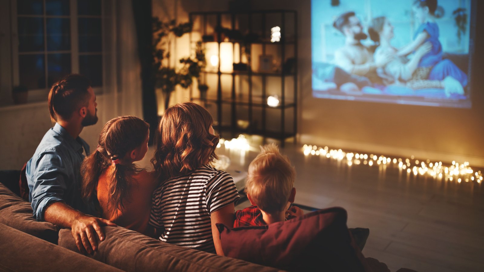 family mother father and children watching projector, TV, movies with popcorn at home Evgeny Atamanenko Shutterstock