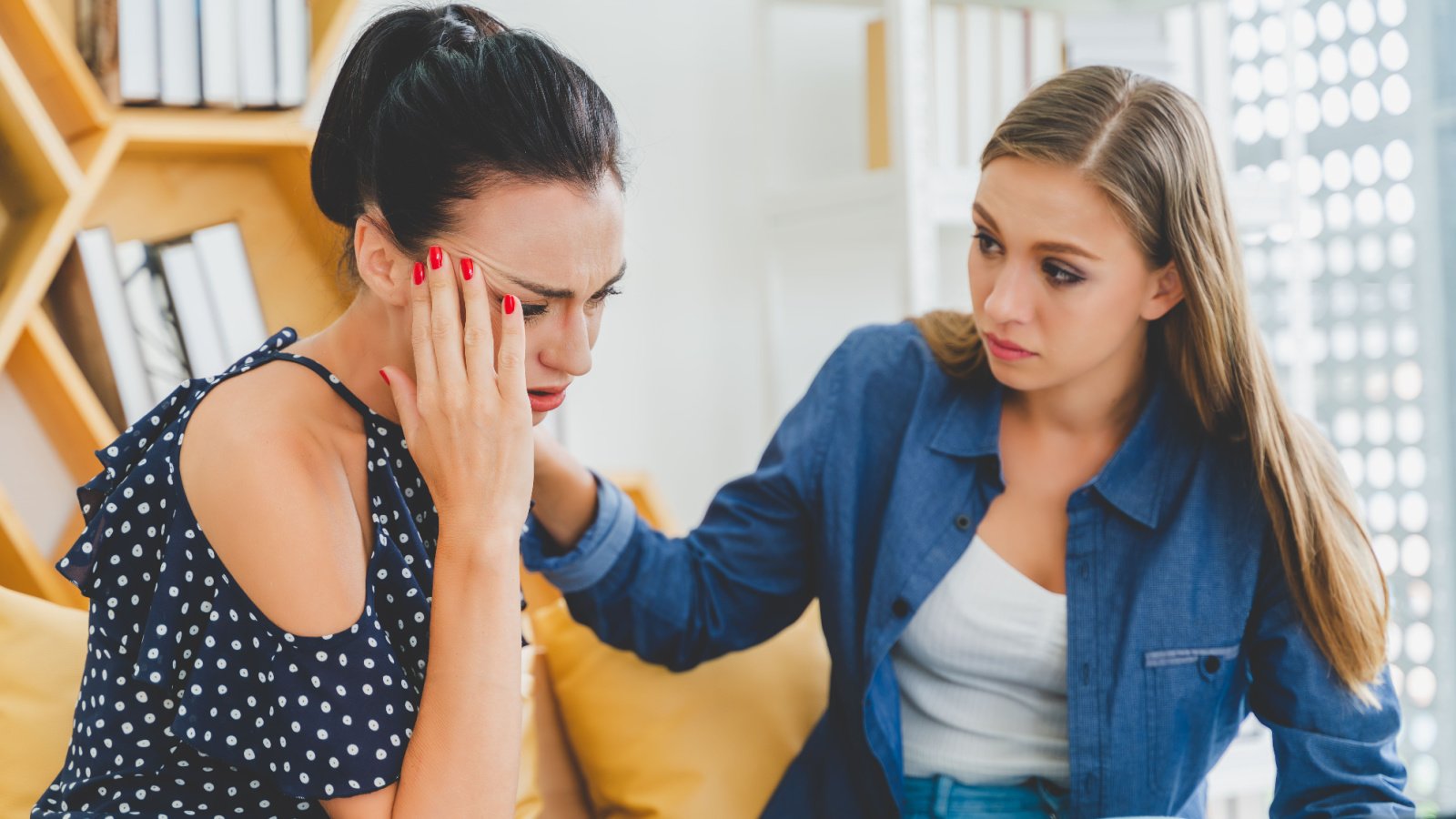 frustrated woman working at office desk in front of laptop suffering from chronic daily headache Crafter shutterstock