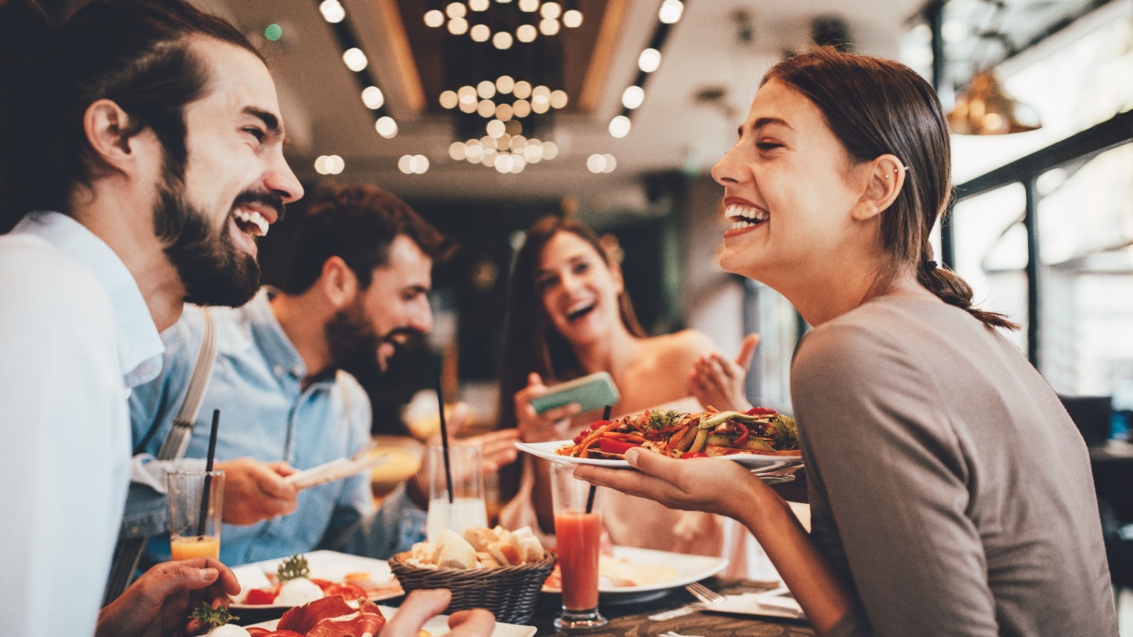 group friends out to dinner restaurant djile shutterstock