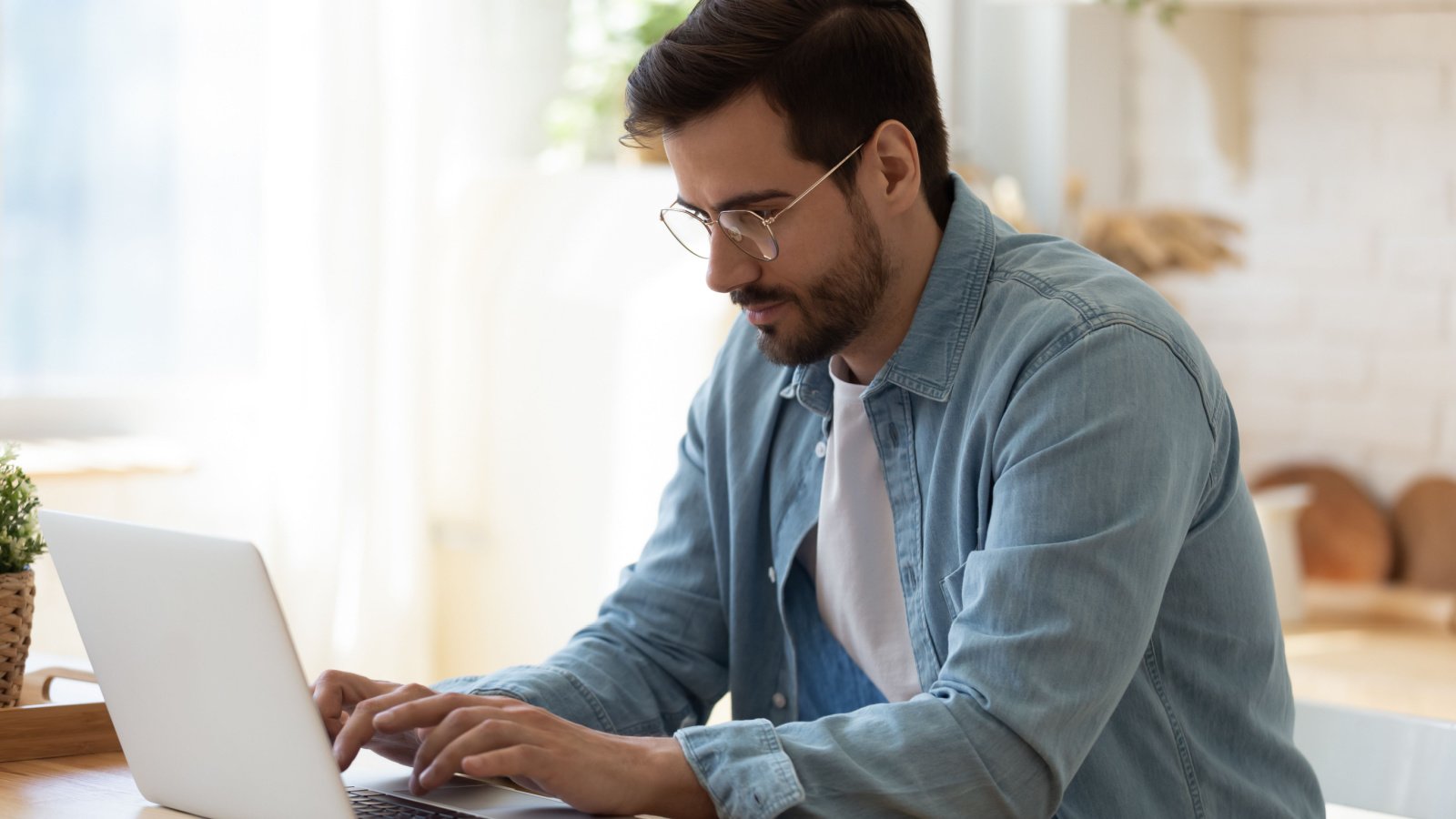 handsome young business male in eyewear working with computer remotely social media work fizkes shutterstock