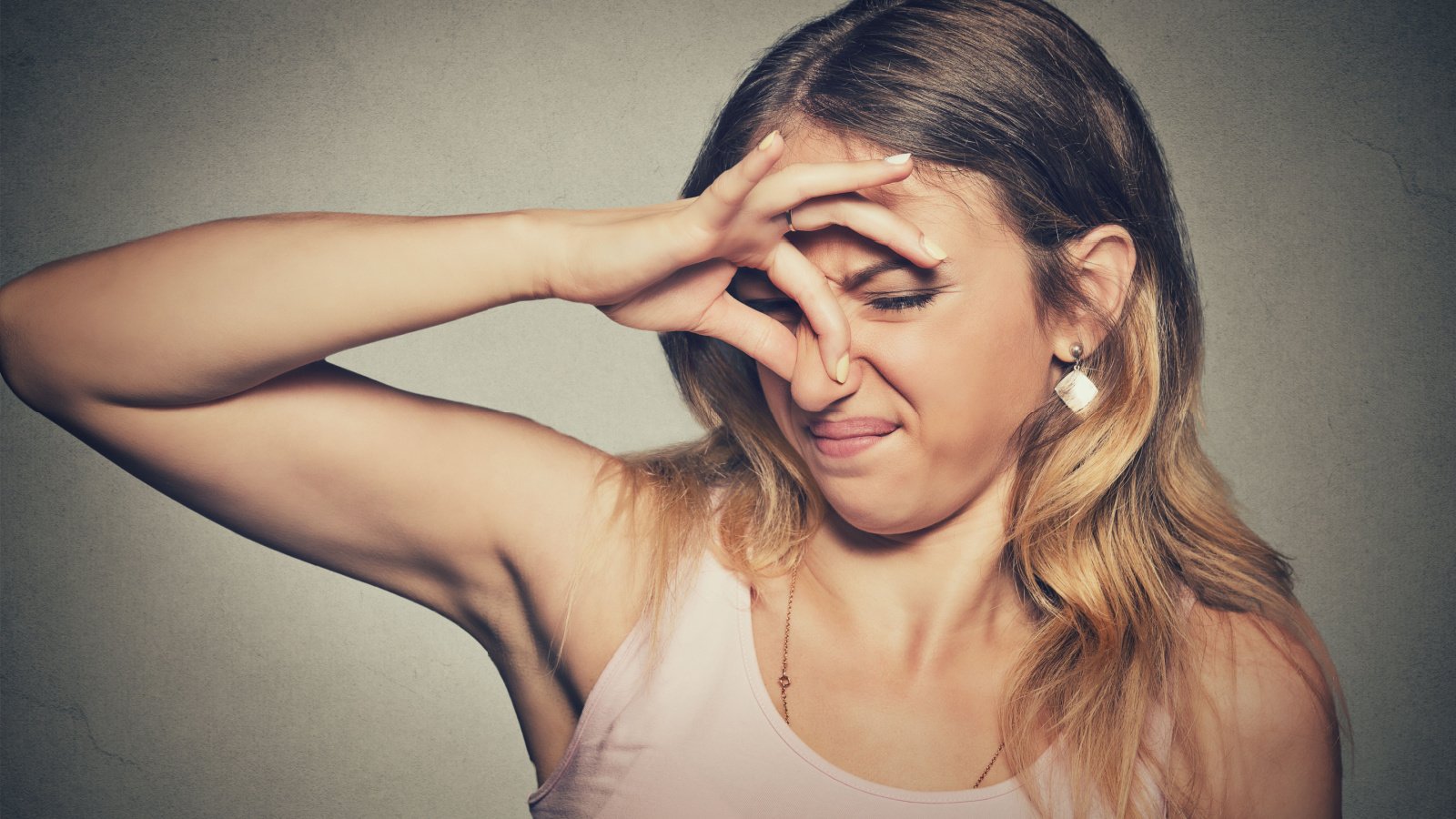 headshot woman pinches nose with fingers hands looks with disgust something stinks bad smell situation nose pathdoc shutterstock