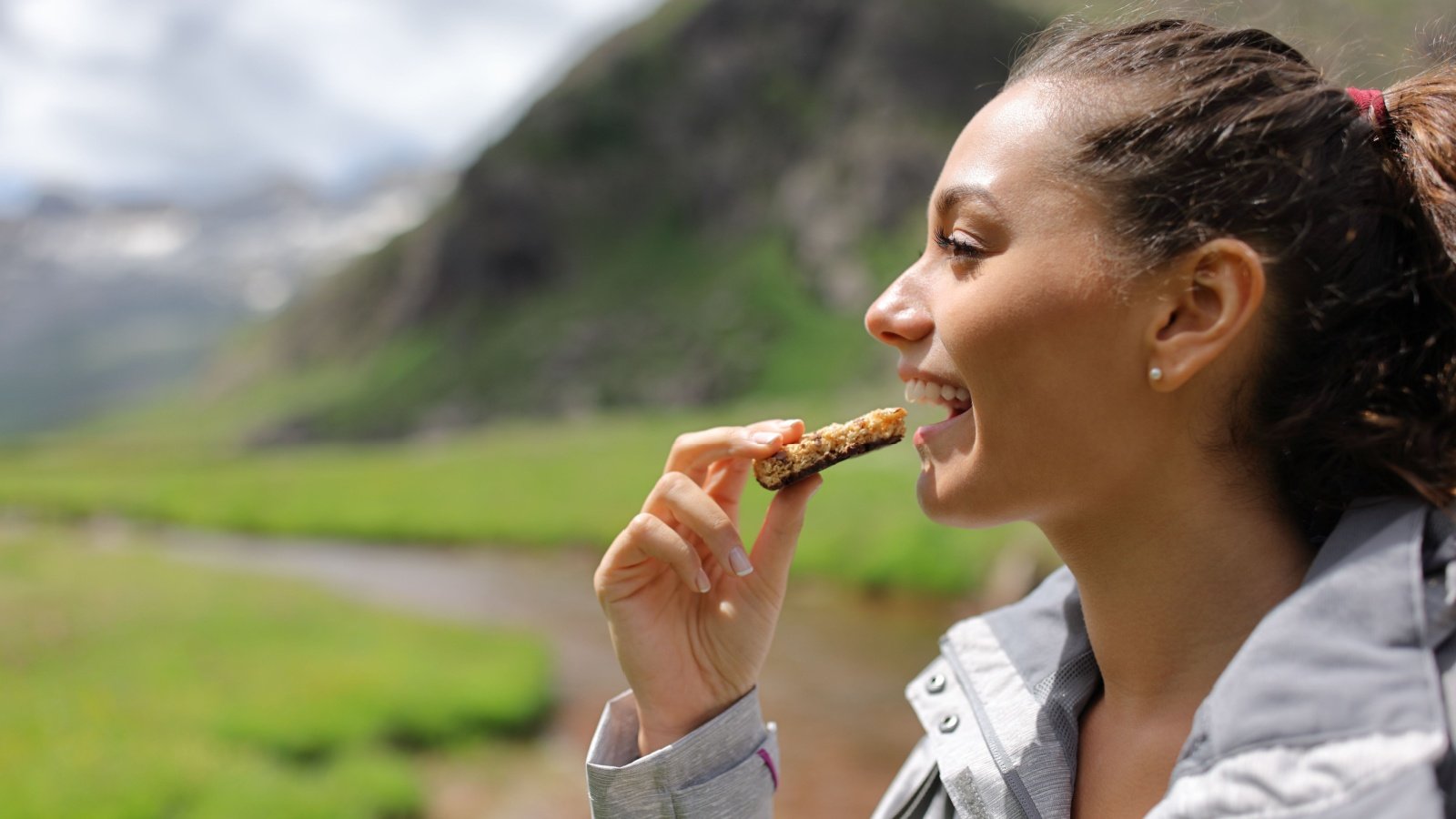 hiker eating a cereal bar granola hiking outdoors snack breakfast travel Antonio Guillem Shutterstock