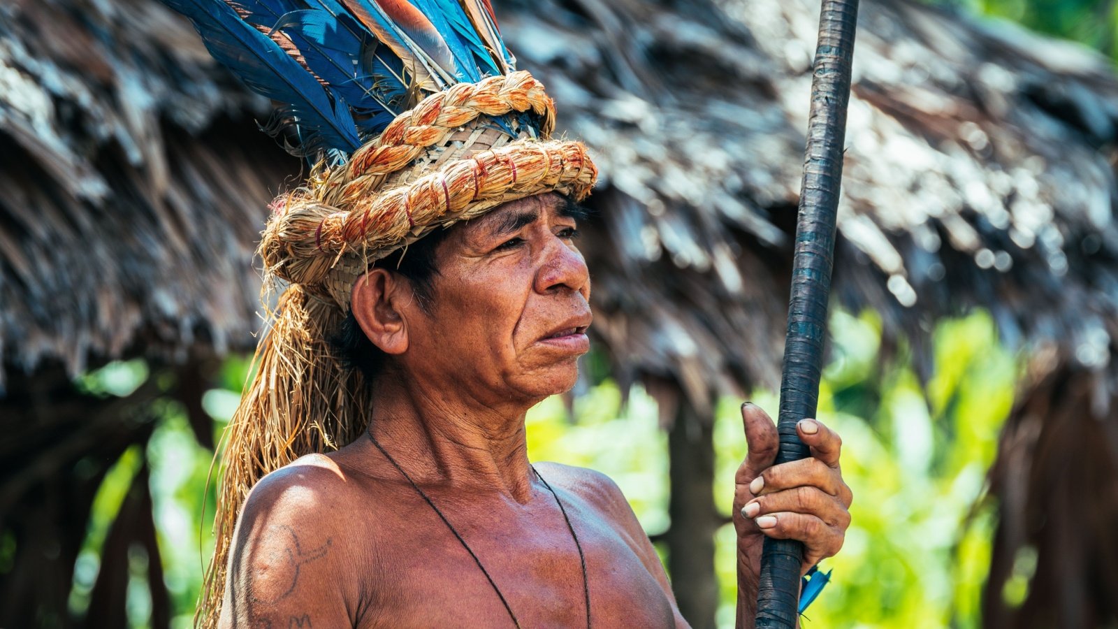 indigenous male at peruvian amazon tribe headdress Jon Chica Shutterstock