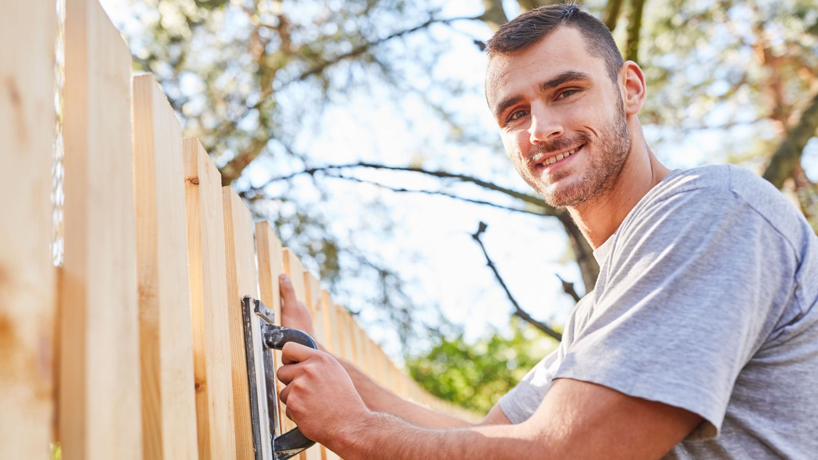 male building a fence craftsman jobs neighbor robert kneschke shutterstock