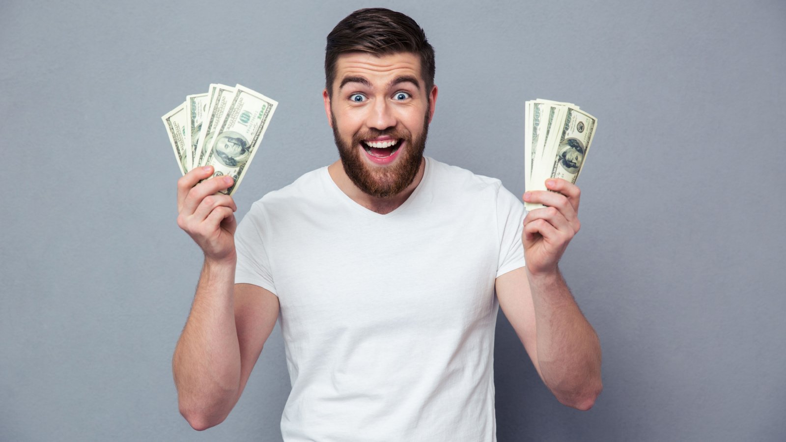 male holding dollar bills money cash dean drobot shutterstock