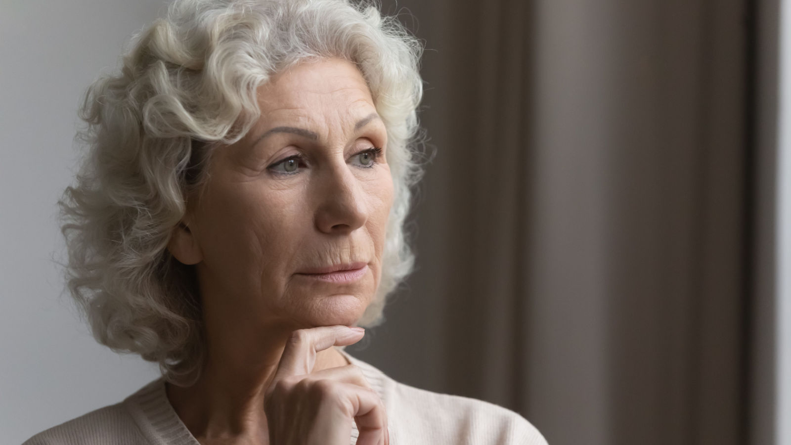 middle aged old woman looking outside at window head shot close up Pensive thoughtful elderly mature grandmother fizkes shutterstock