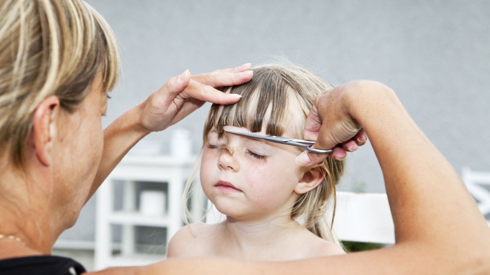 mother cutting daughters hair gemenacom shutterstock