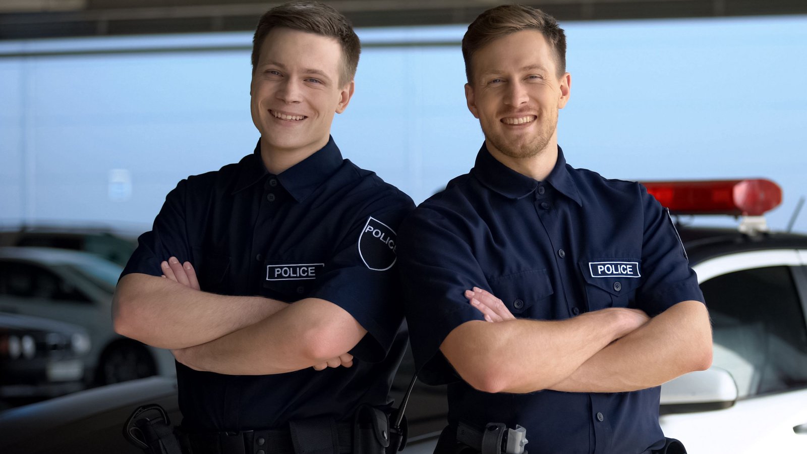 police officiers with hands crossed standing against squad jobs motortion films shutterstock