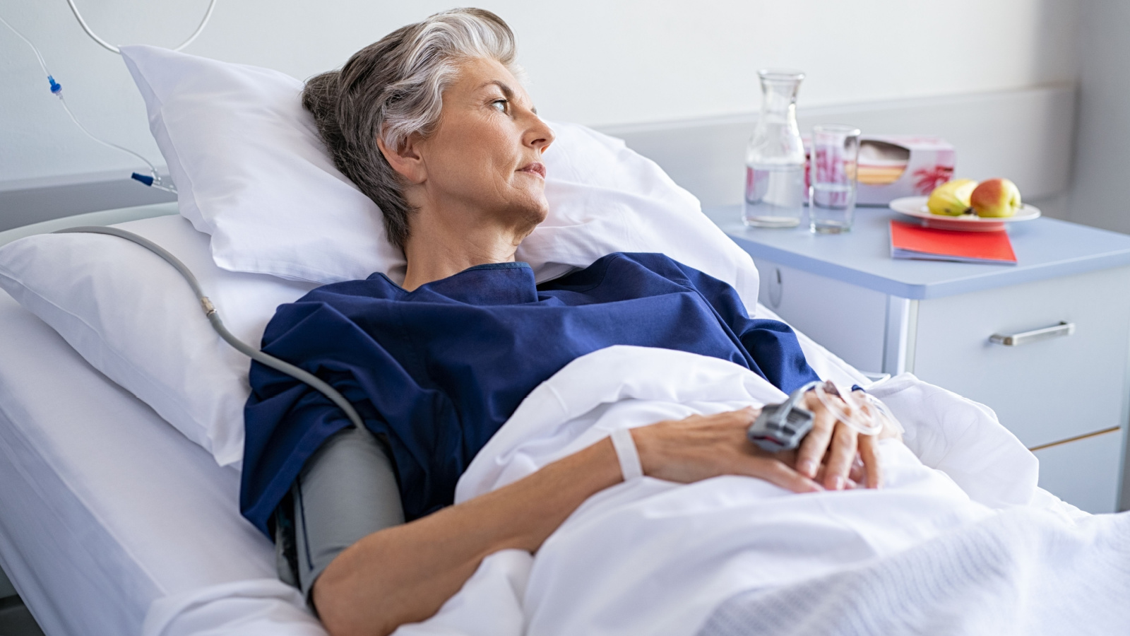 sad old woman lying on hospital bed senior ill rido shutterstock