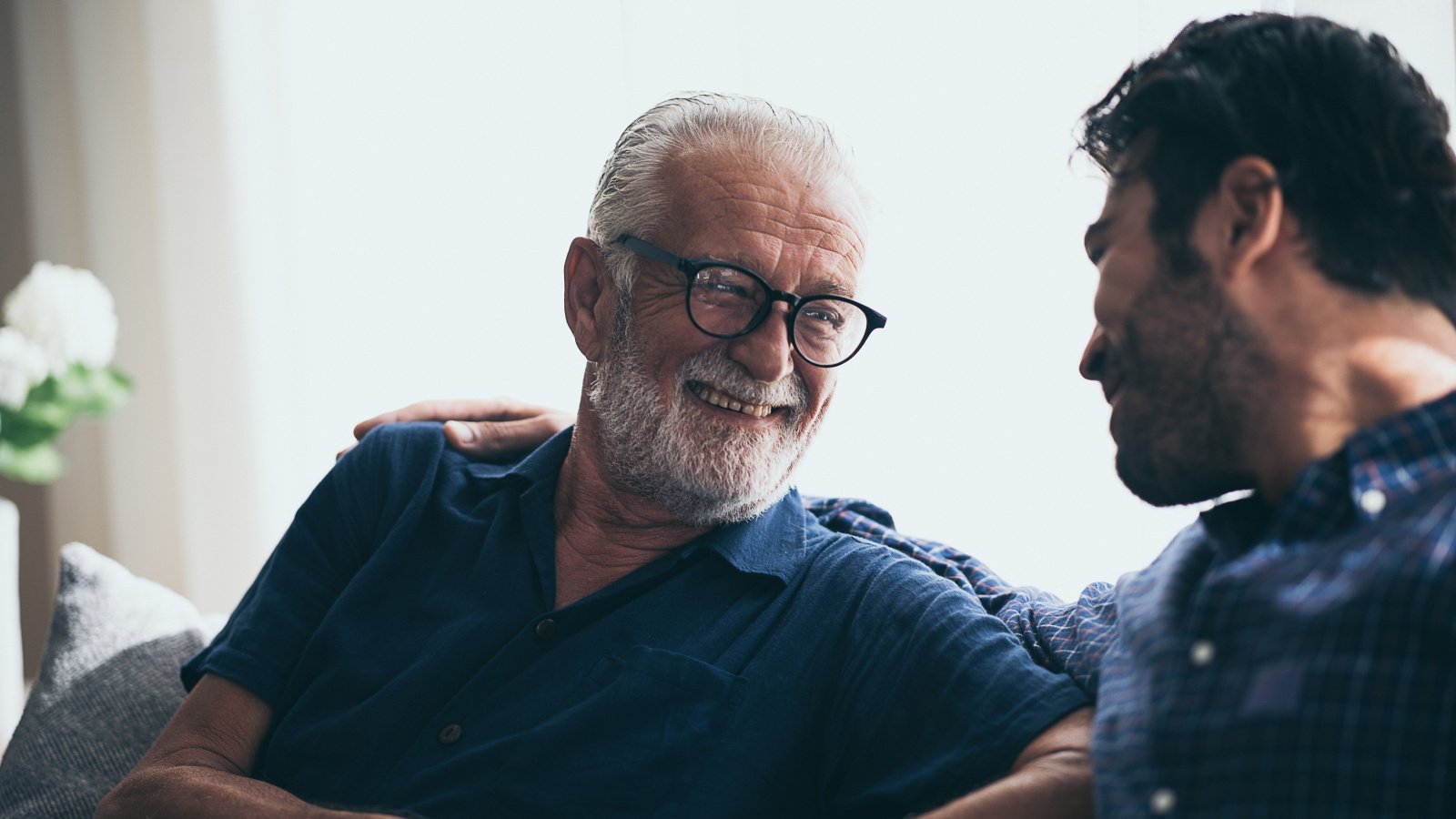 senior father with adult son on sofa