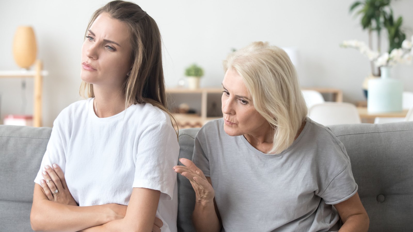 senior mother back away on couch in with young daughter girl teenager fighting fizkes shutterstock