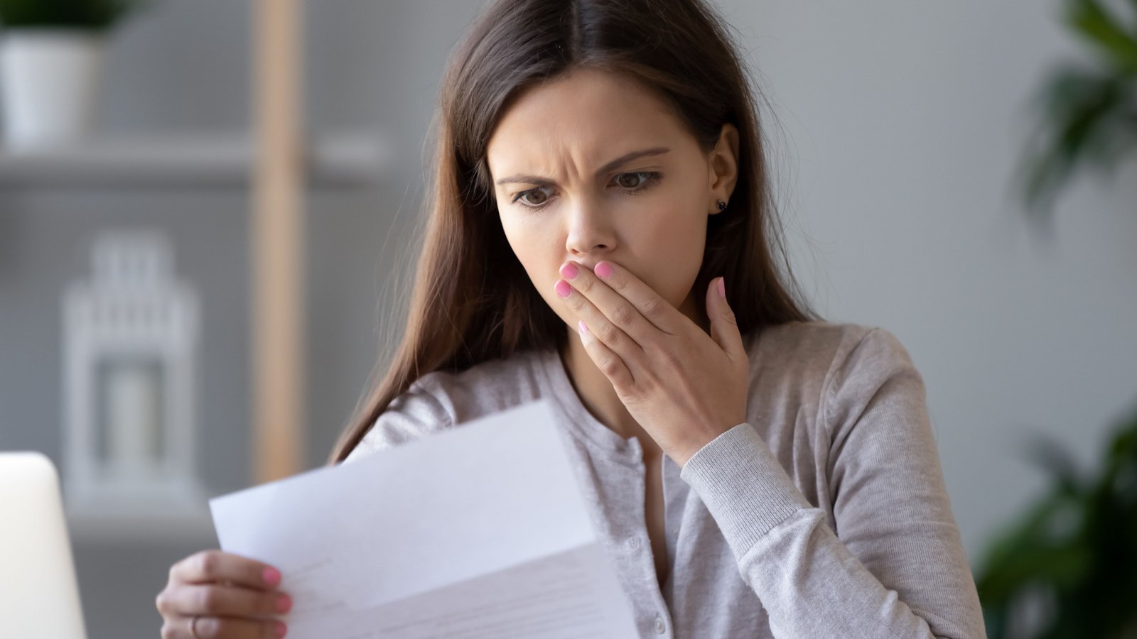 stressed young woman reading document letter bank loan debt financial problem letter fizkes shutterstock