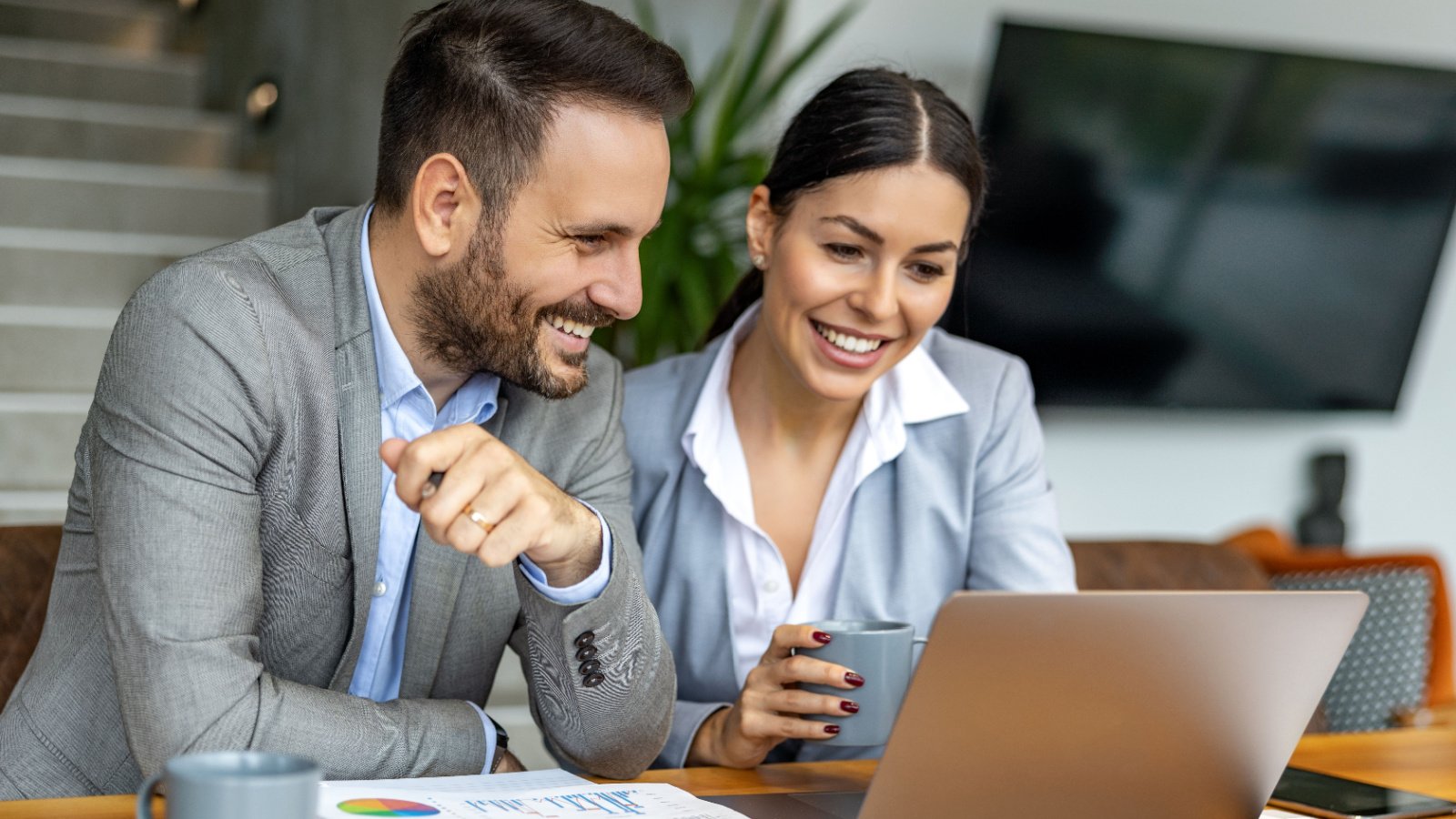 two business people using laptop and discussing about new project at office work couple investing ivanko80 shutterstock