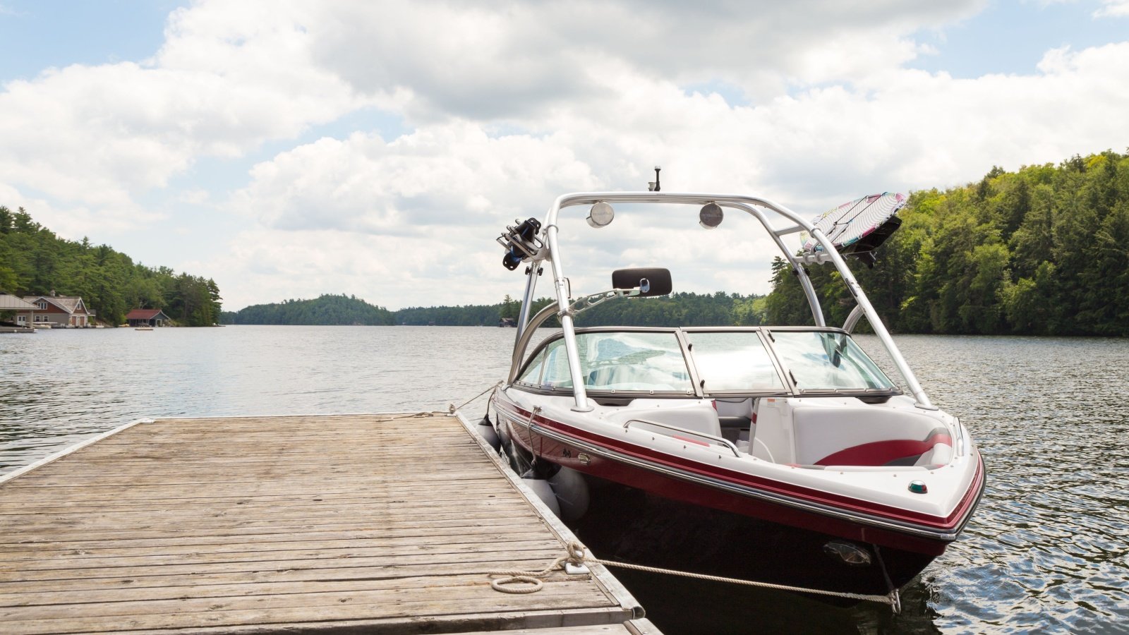 wakeboard boat at a wooden dock speed boat lake vacation sunny day boating Adam Melnyk Shutterstock