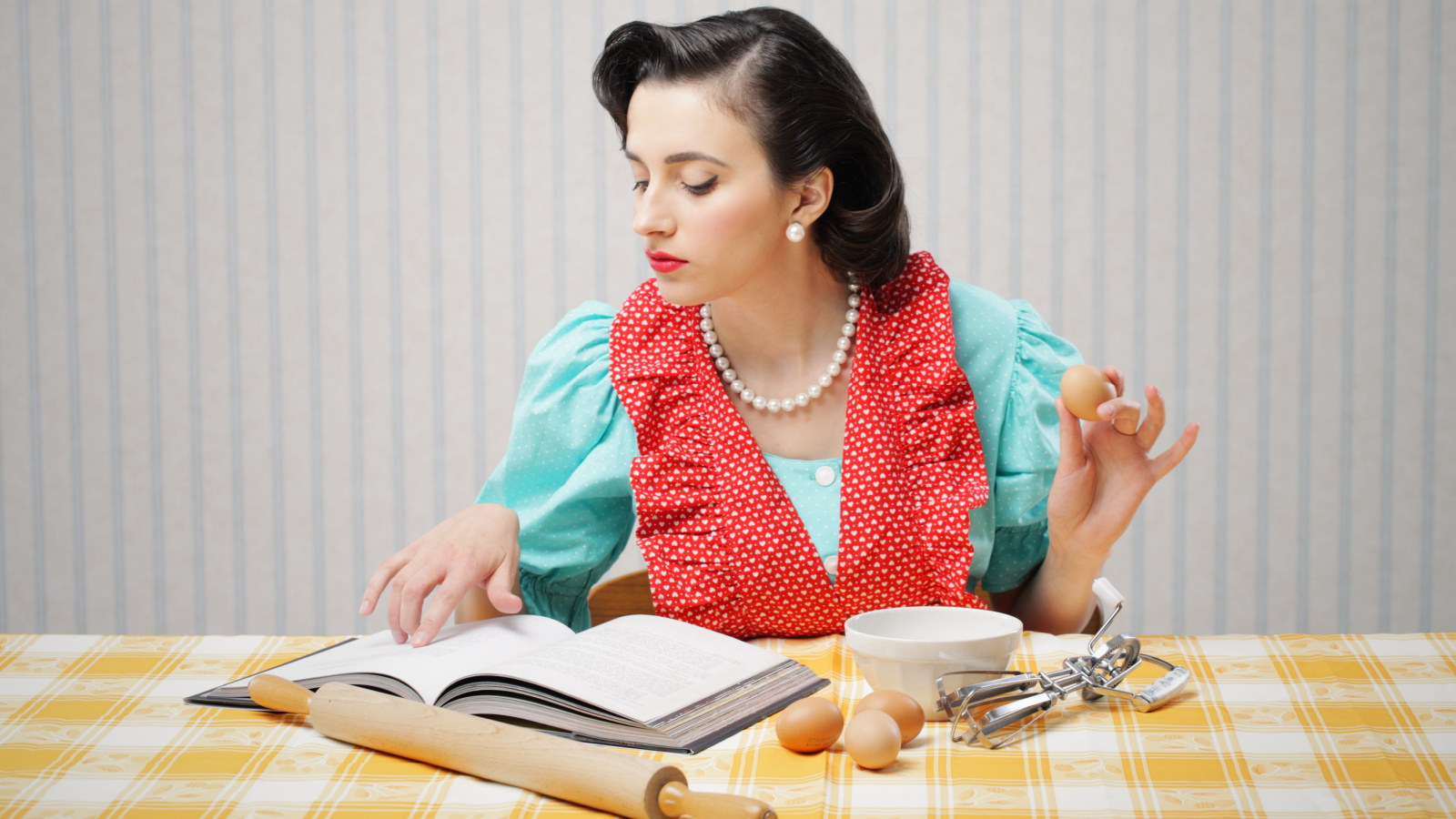 woman looking at a recipe for a cake cookbook bake stokkete shutterstock