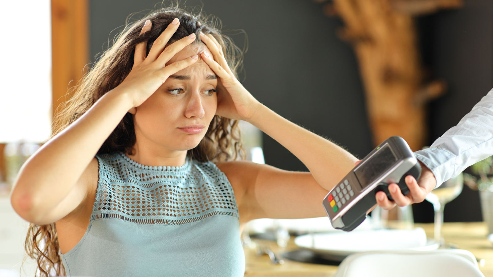 woman stressed over bill tip at restaurant Pheelings media shutterstock