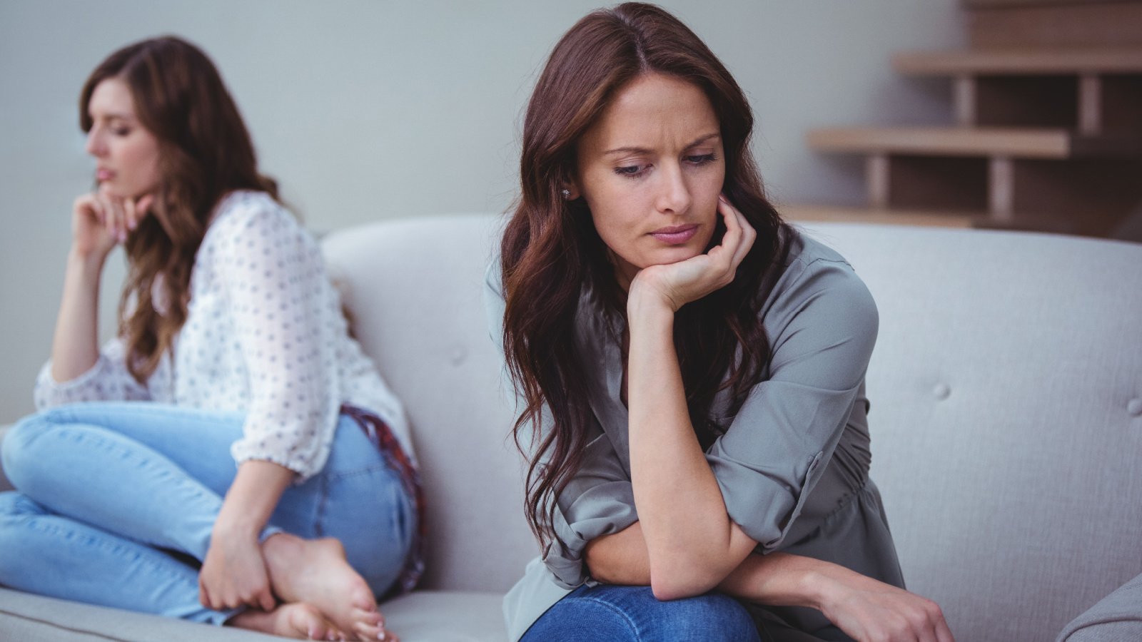 women sitting on a sofa and ignoring her friend after an argument wavebreakmedia shutterstock