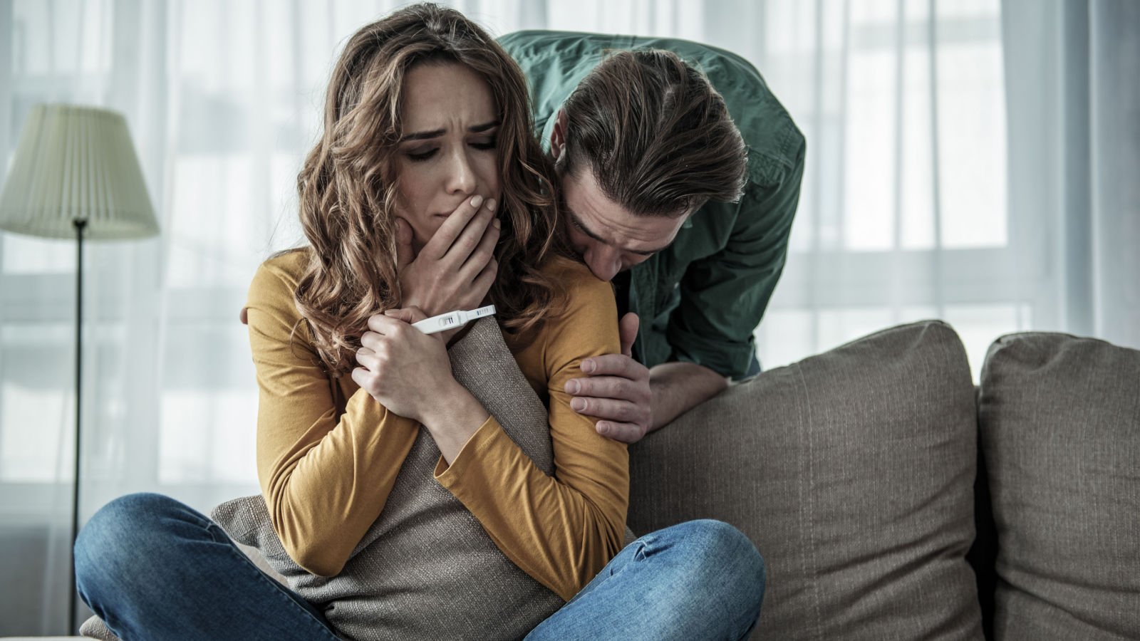 worried couple holding pregnancy test stick olena yakobchuk shutterstock