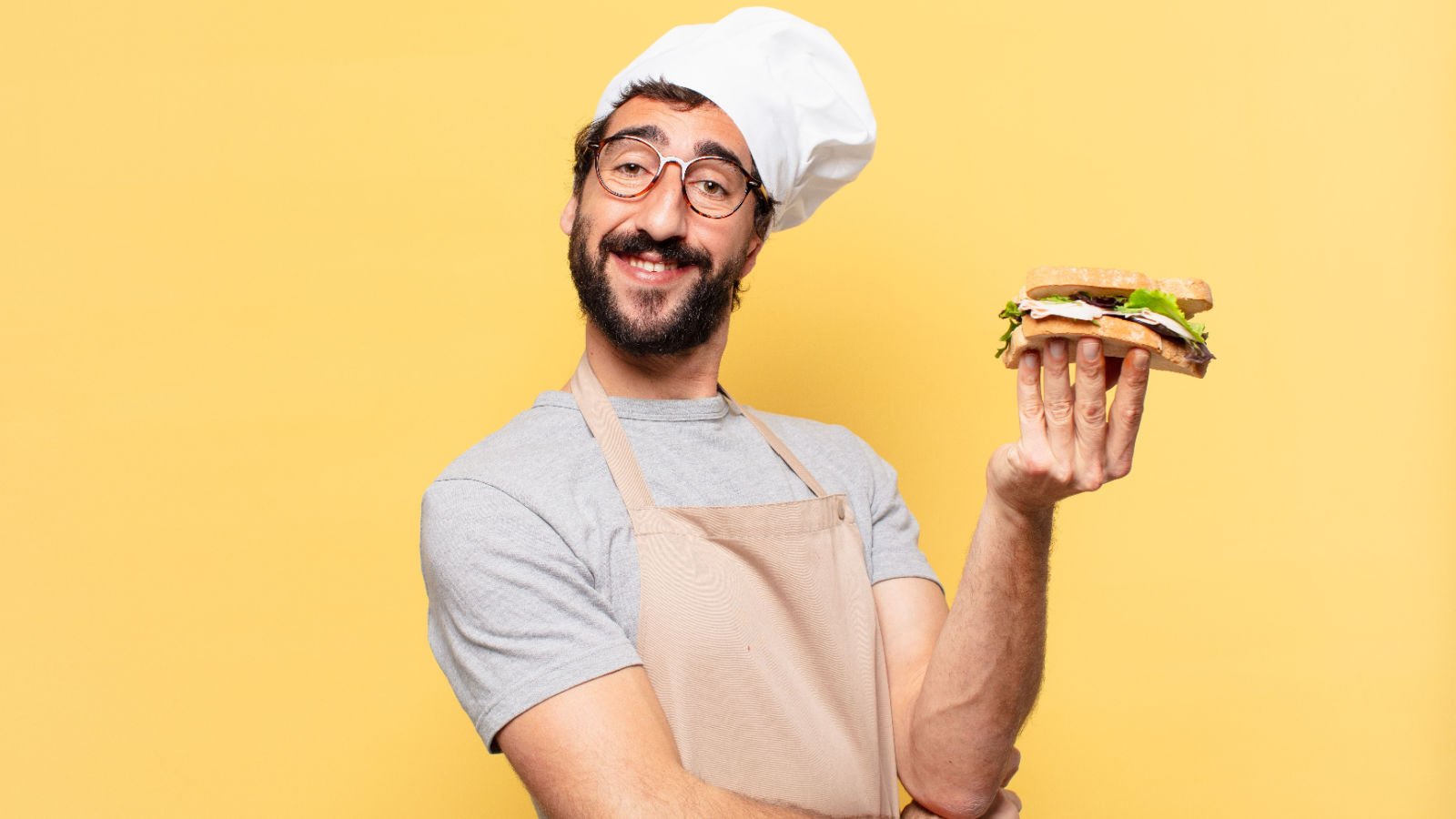 young bearded chef man holding a sandwich jobs kues shutterstock