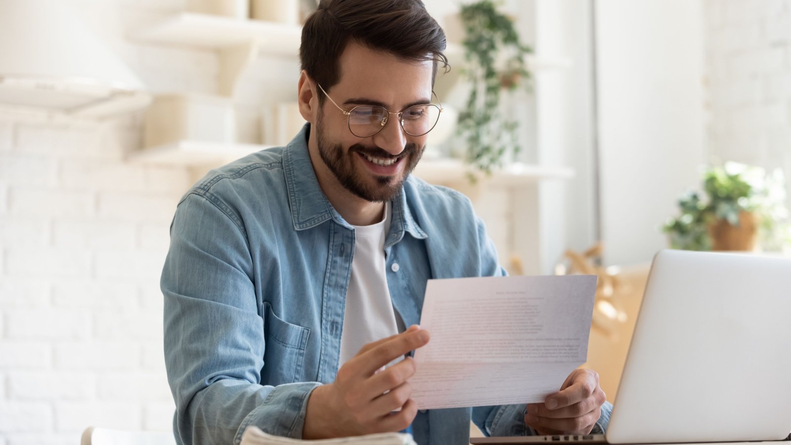 young male reading letter good news in paper notification fizkes shutterstock