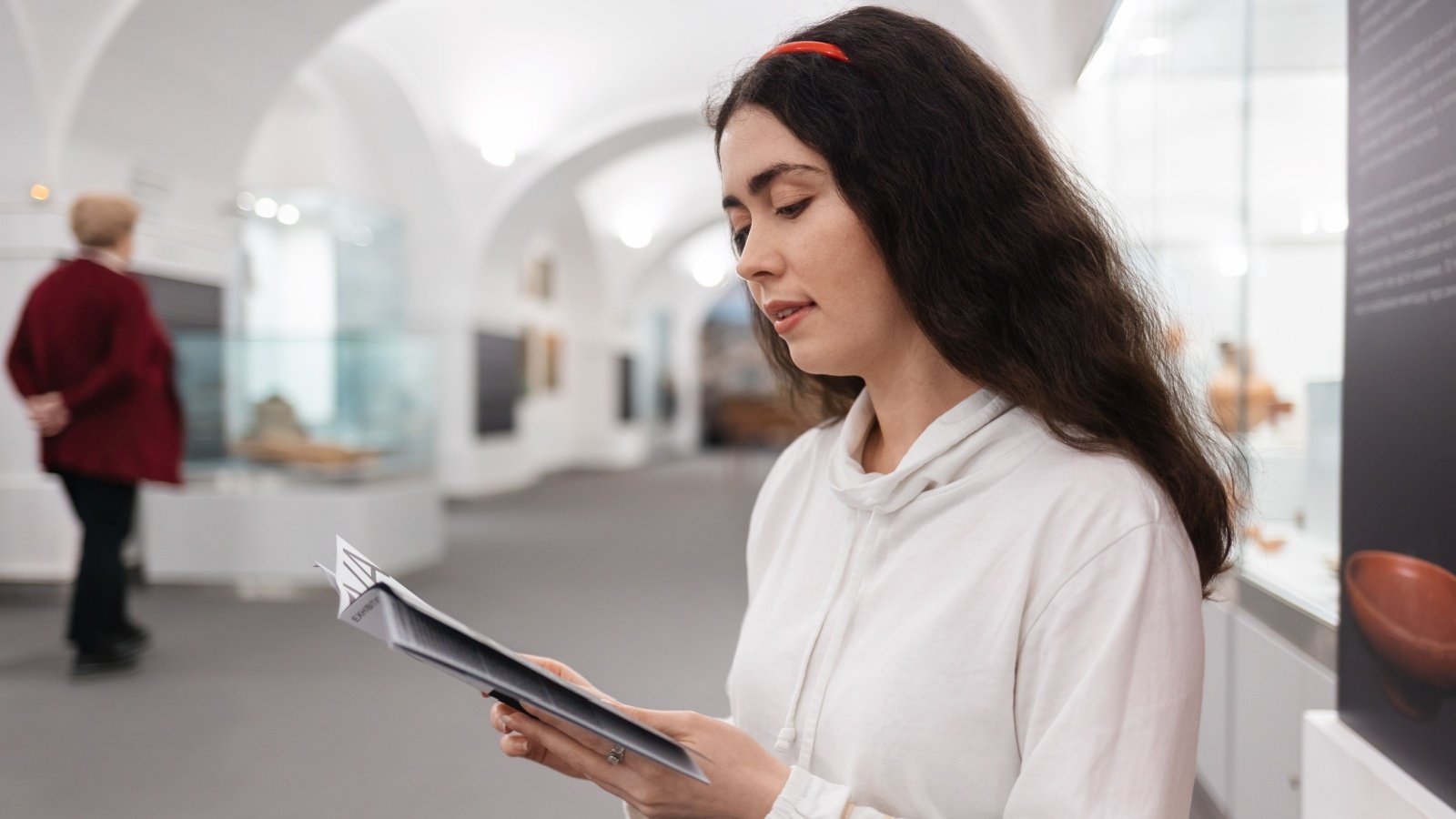 young woman student visiting museum and reading brochure pamphlet learning history visitor center student STEKLO Shutterstock