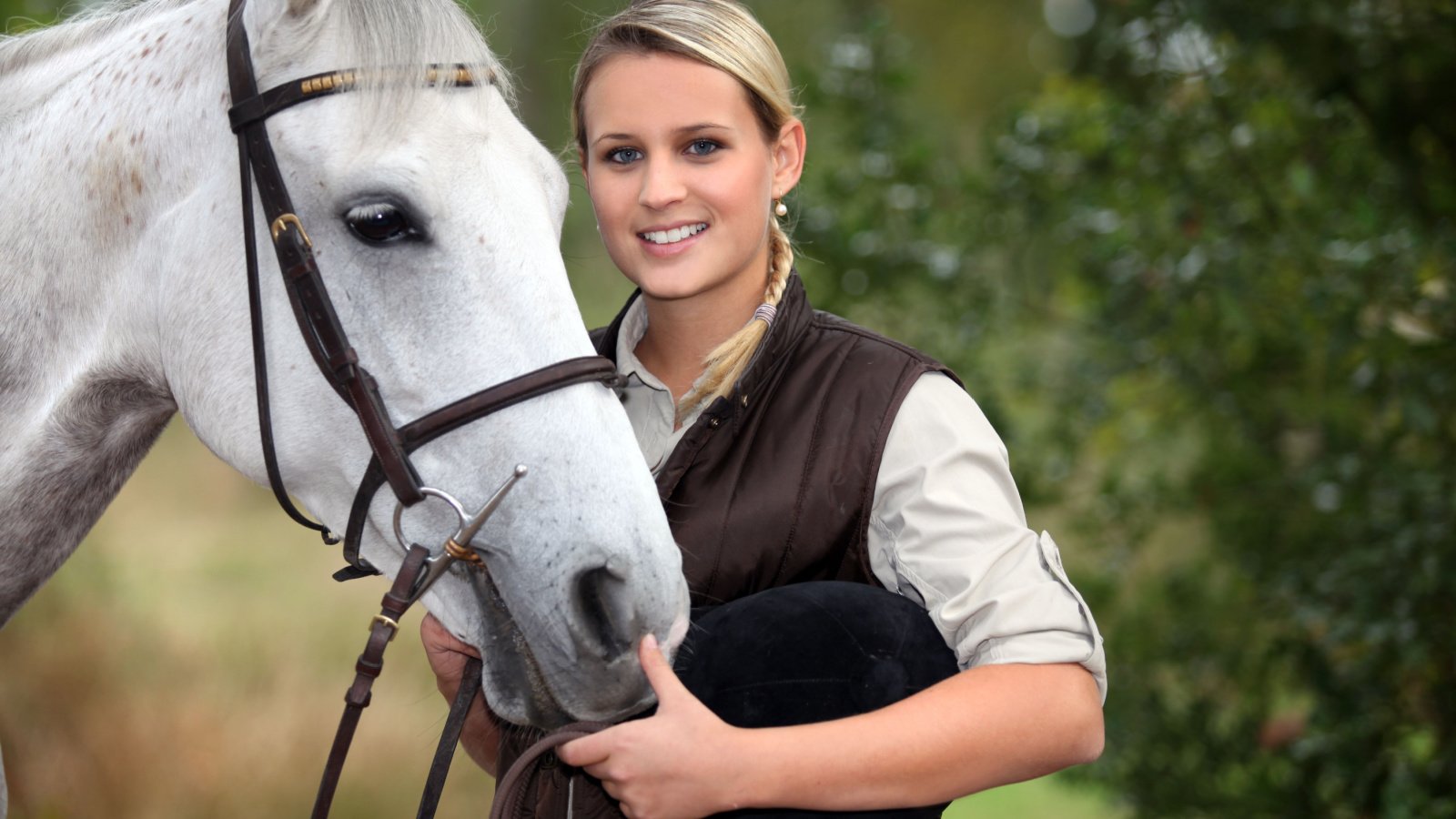 young woman taking care of her horse phovoir shutterstock